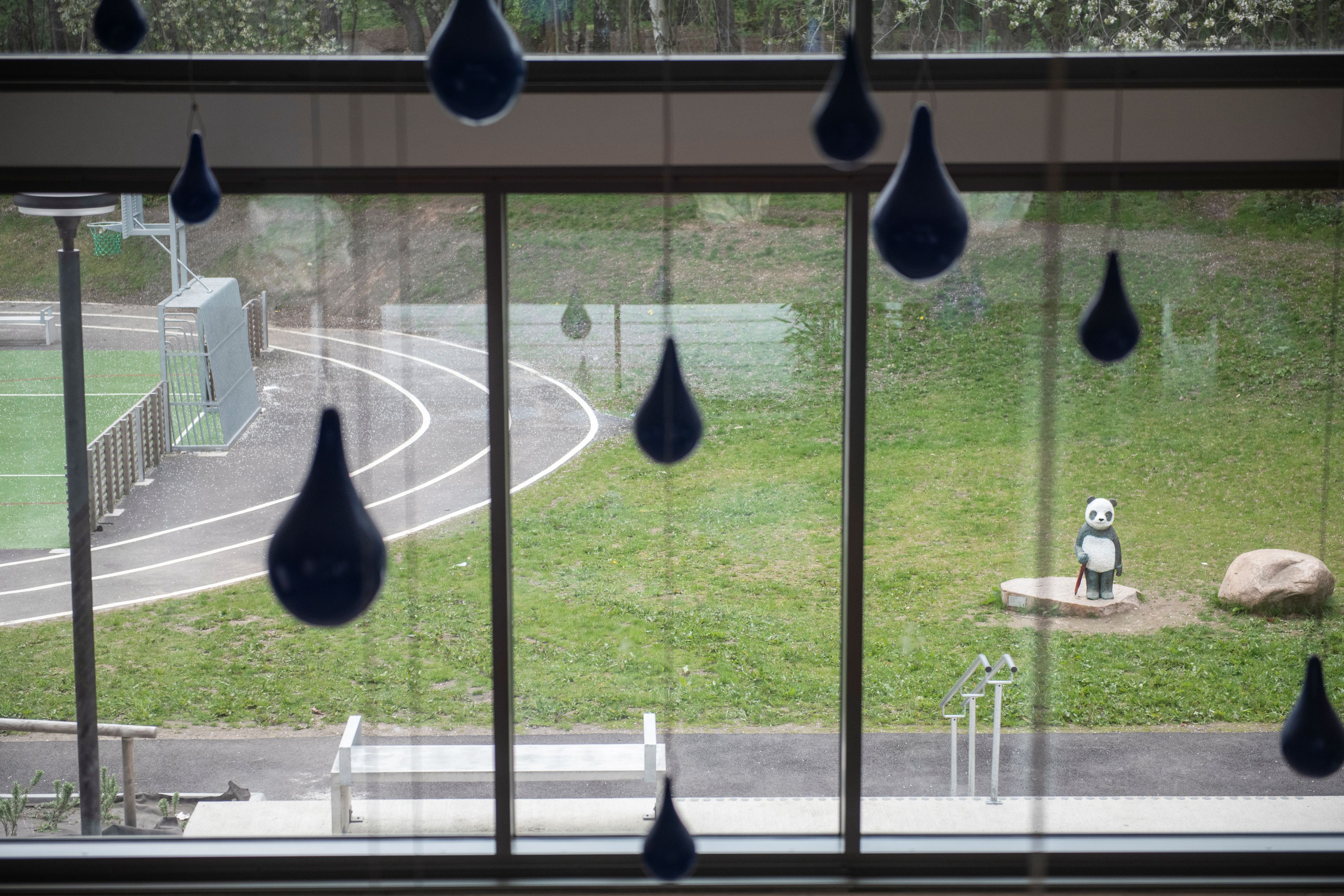 Regndroppar i metall och en panda med paraply