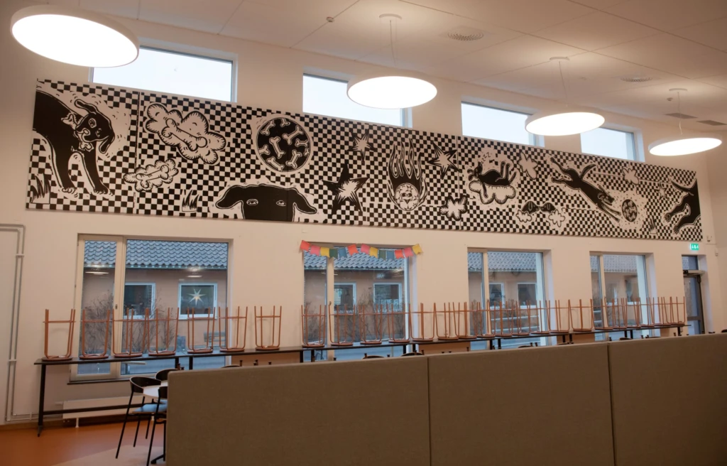 Matsal med bild på väggen som föreställer lekfulla hundar.