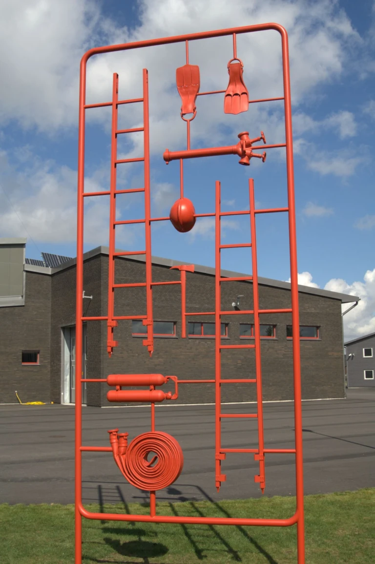 Skulptur som ser ut som en byggsats med brandmansutrustning.