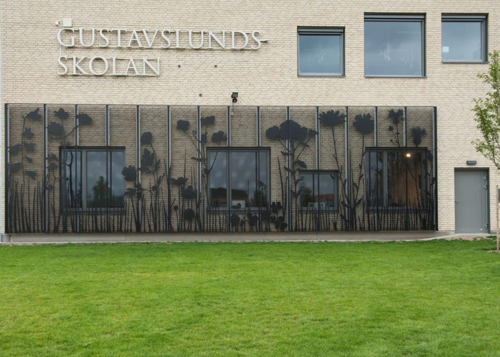 Fasadkonstverk som visar en stiliserat äng i svart metall.