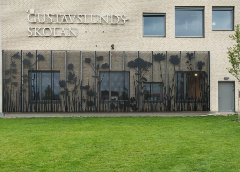 Fasadkonstverk som visar en stiliserat äng i svart metall.