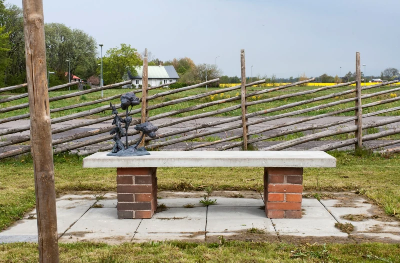 Bänk med skulptur av träd på. 