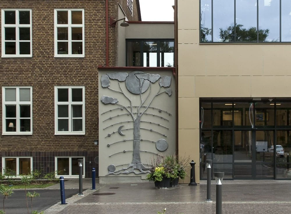 Konstverk på vägg i form av ett stiliserat Livets träd.