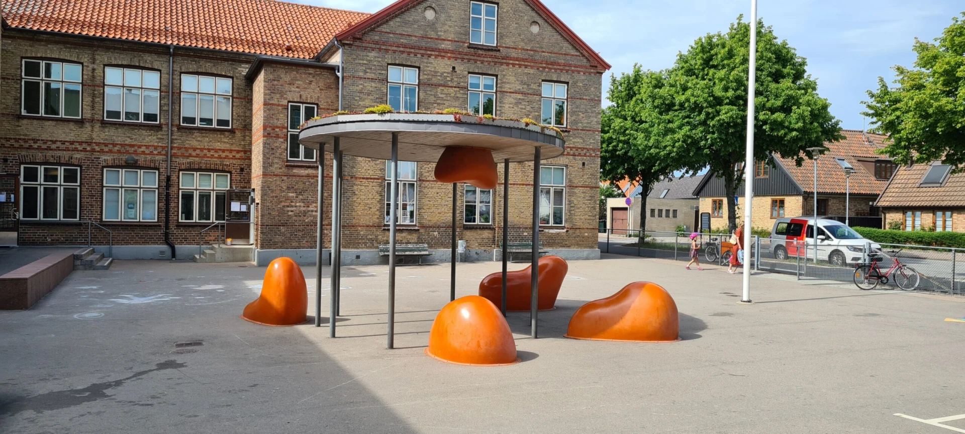 Orangea skultpurer om dagen på skolgård
