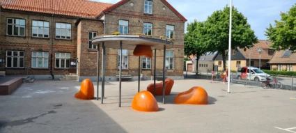 Orangea skultpurer om dagen på skolgård