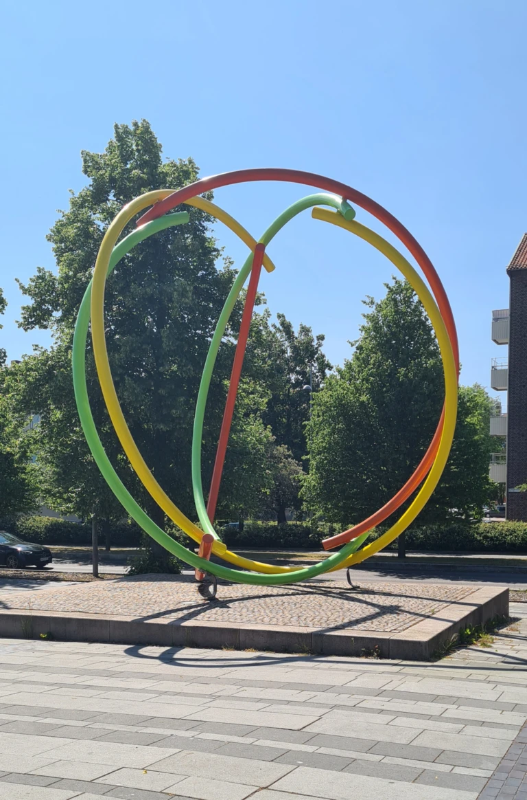 Skulptur i starka färger i form av bågar som bildar en sfär.