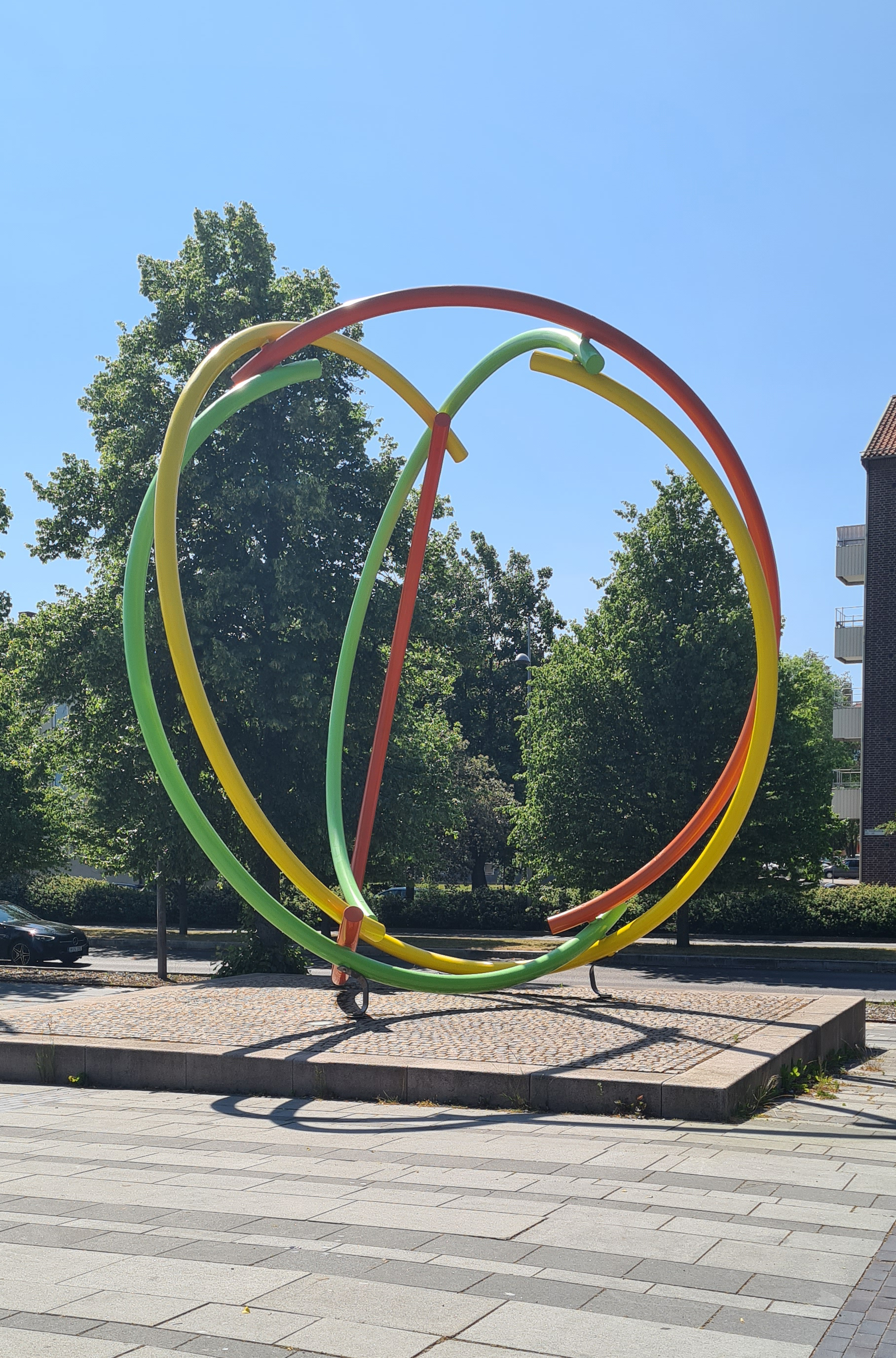 Skulptur i starka färger i form av bågar som bildar en sfär.