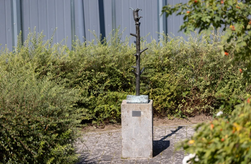 Konstverk i form av katt som försöker likna stammen på ett träd.