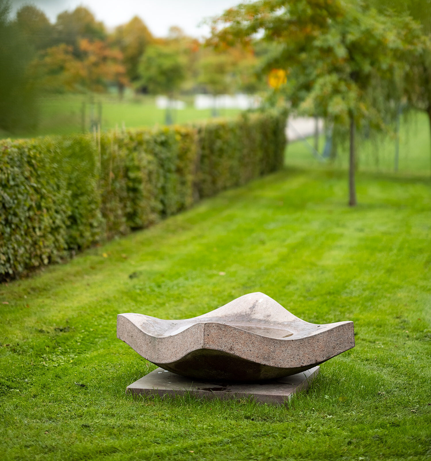 Skulptur i form av en böljande fyrkant i sten.