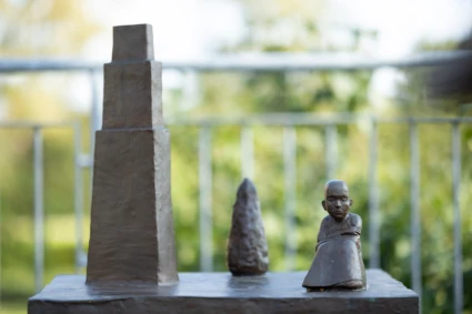 Skulptur med en en, en byggnadsform och en flicka.