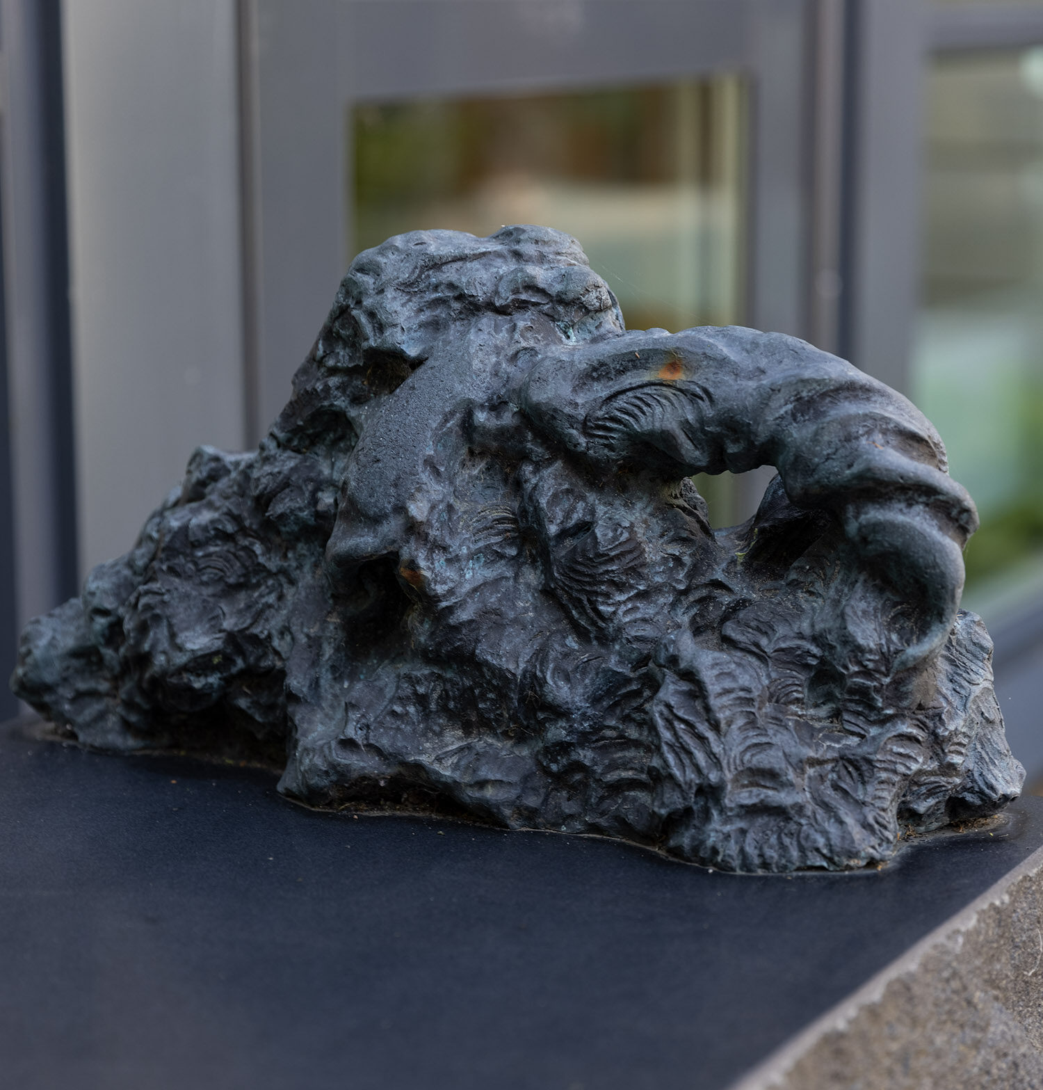 Detalj från konstverk i form av bänk i brons och sten.