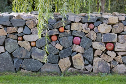 Konstverk i kallmur bestående av glasbollar i rött.