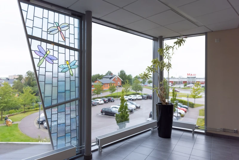 Konstverk i form av glaspanel med motiv av trollsländor.