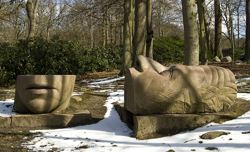Skulptur i sten av ett delat ansikte.