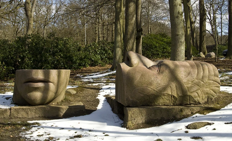 Skulptur i sten av ett delat ansikte.