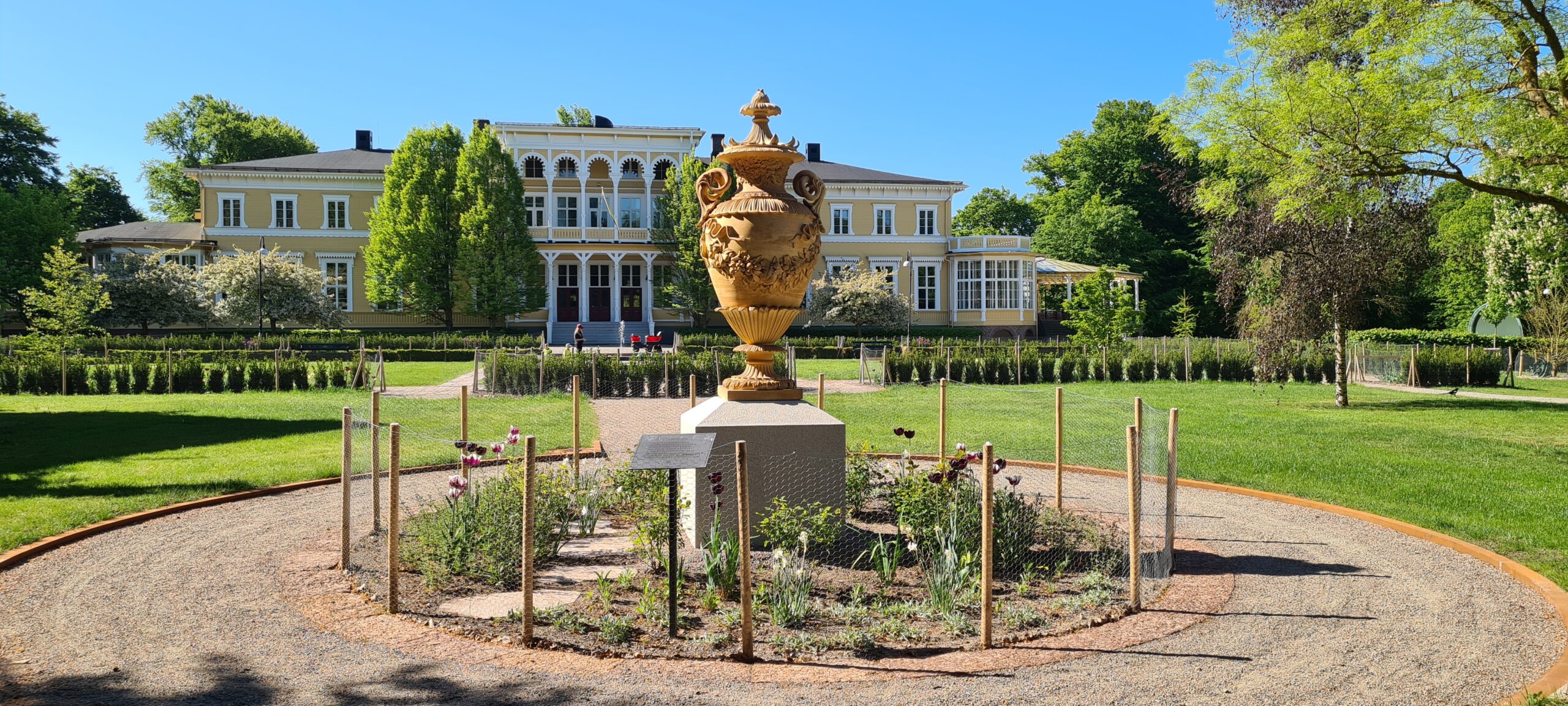 Urna i lergods i trädgård.