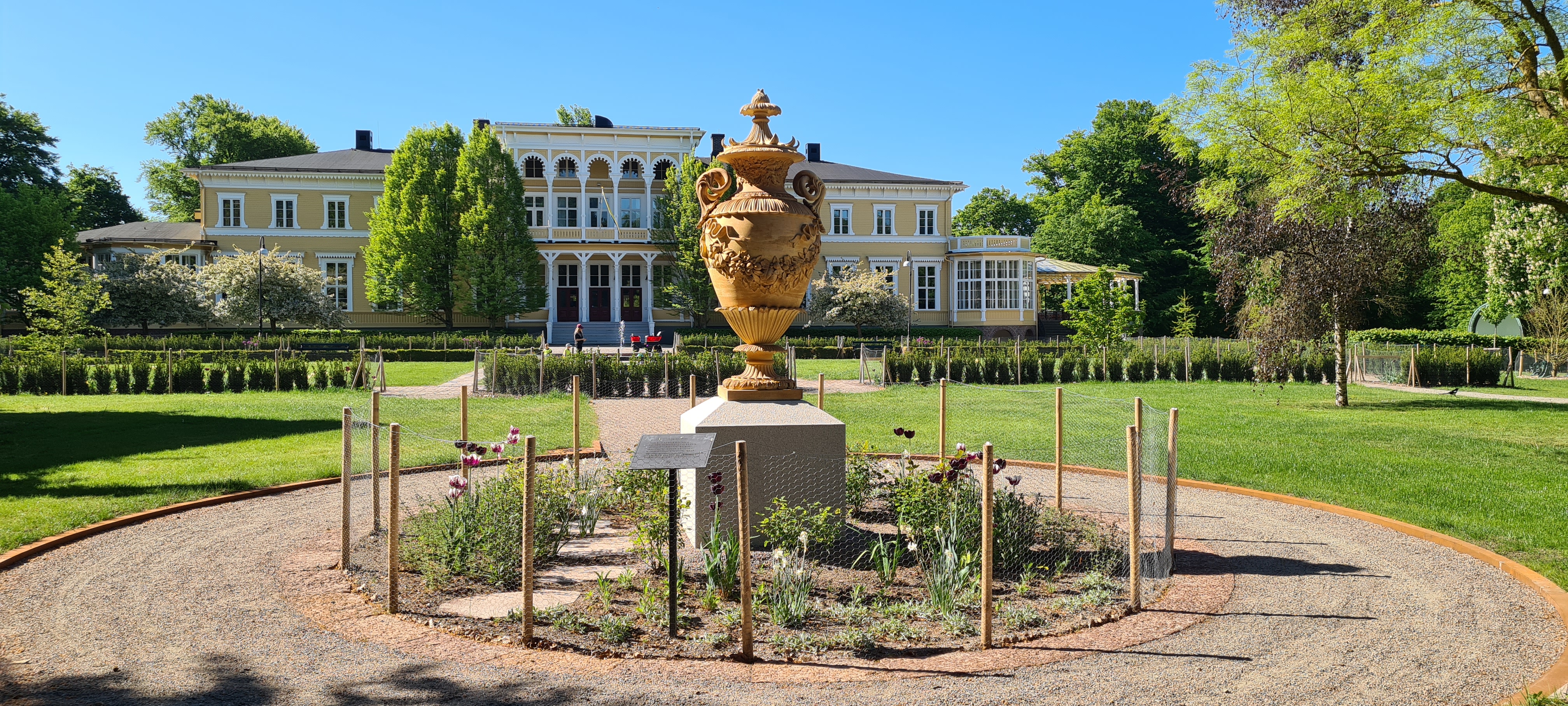 Urna i lergods i trädgård.