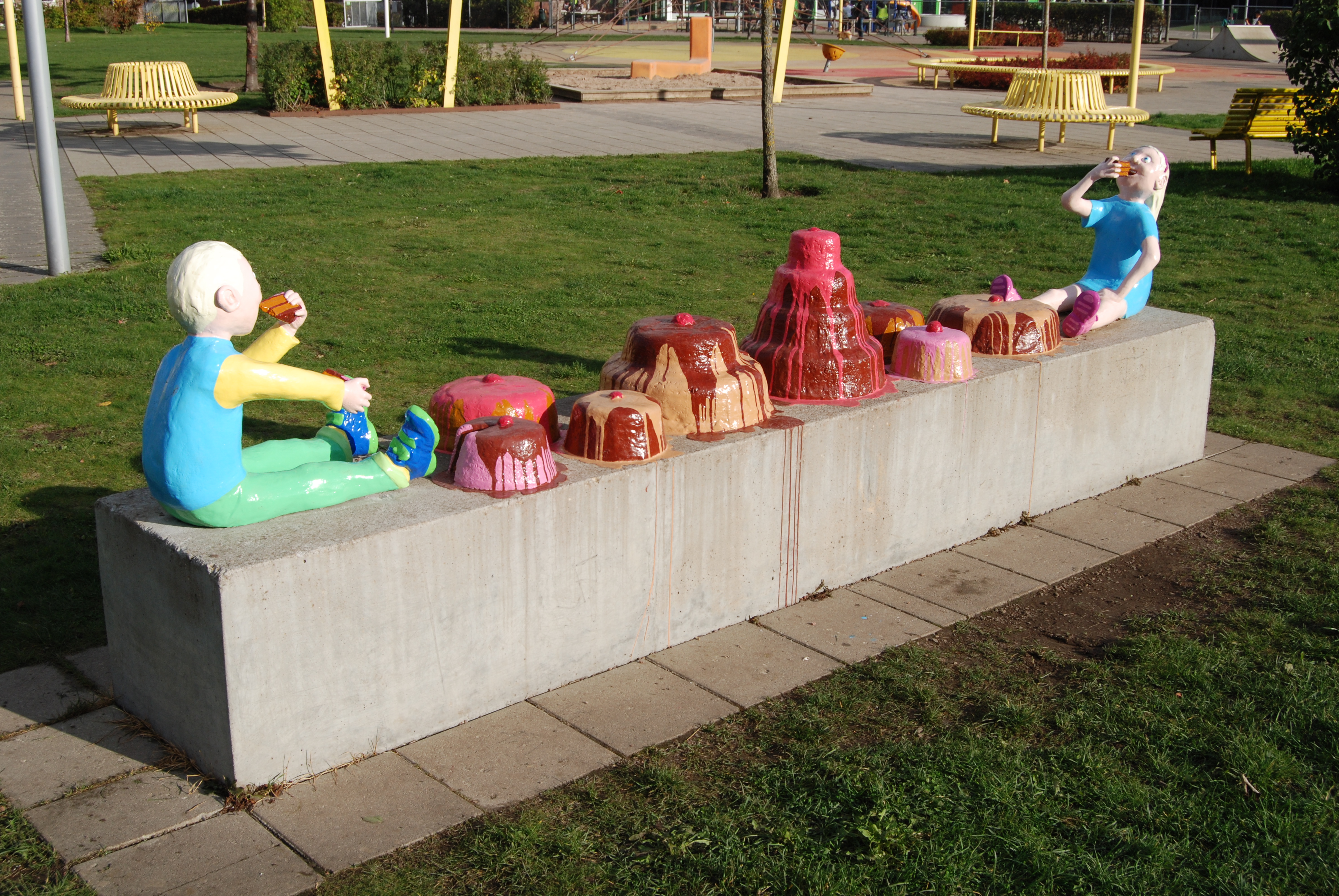 Skulptur med två barn som proppar i sig tårta.