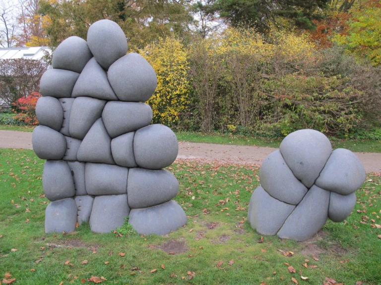 Skulpturkomposition med rundade former i svart sten.