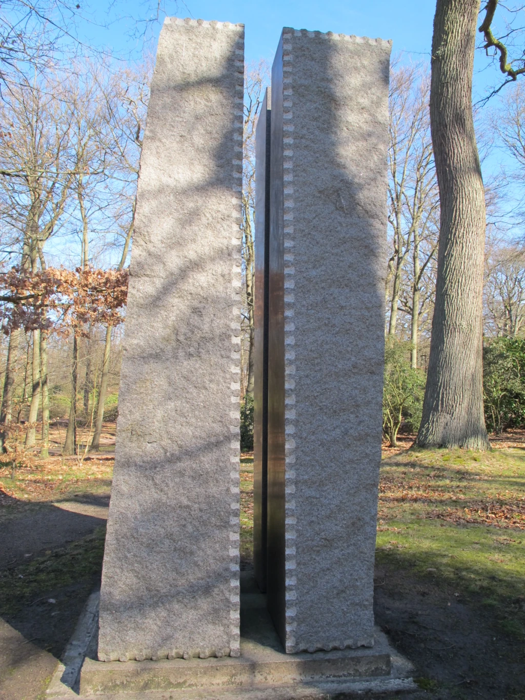 Skulptur i form av fyra höga, fyrkantiga pelare.