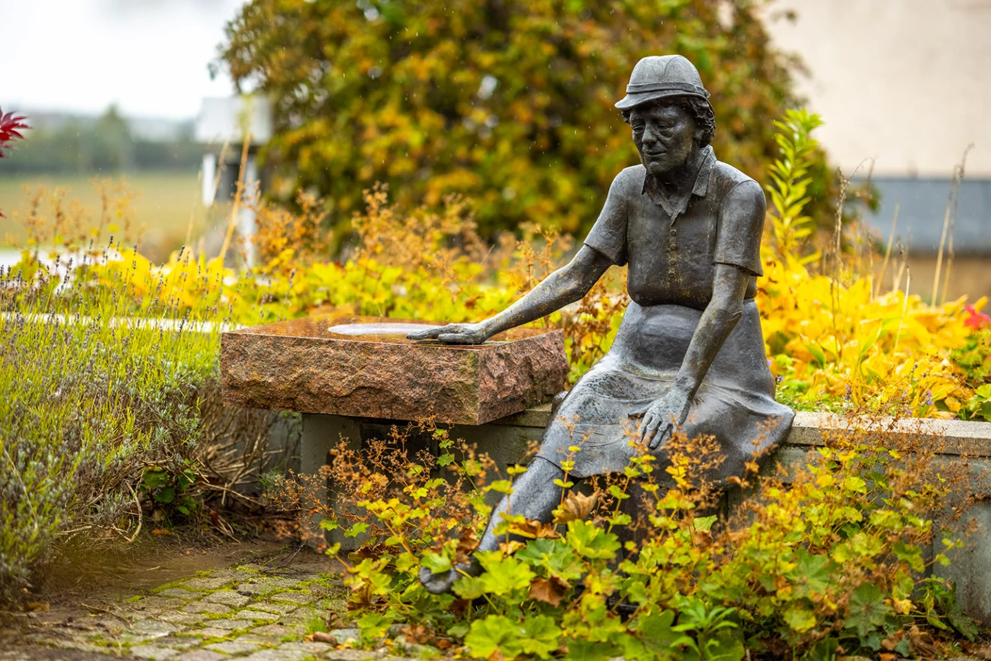 Bronsskulptur av en gammal kvinna som njuter av ett fotbad.