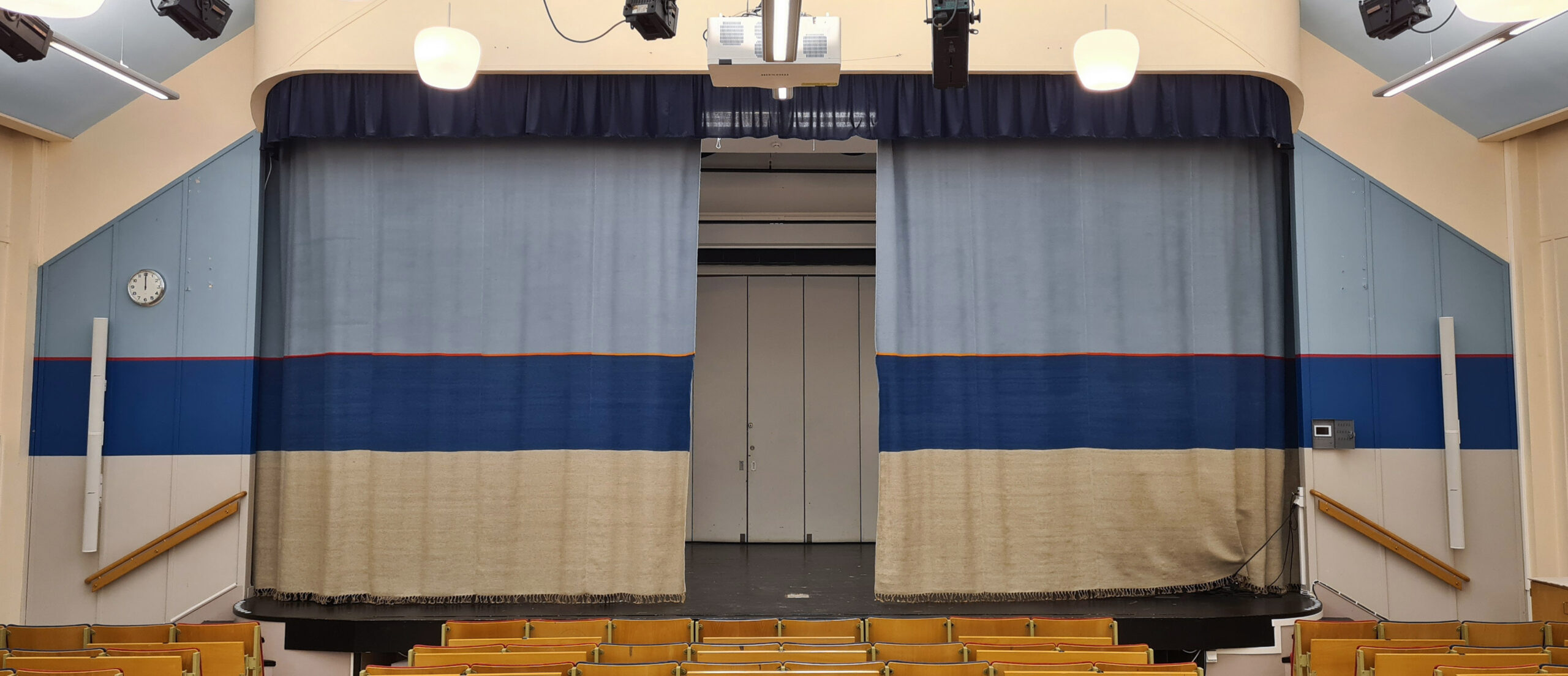 Ridå i form av en stiliserad sandstrand med himmel och hav.