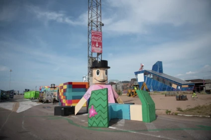 Utomhusbild av en skulptur av en glad gubbe i hamnmijö.