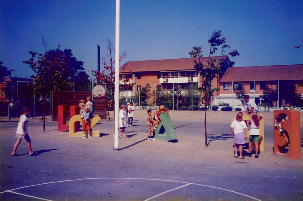 Utomhusbild med lekande barn på skulptur.
