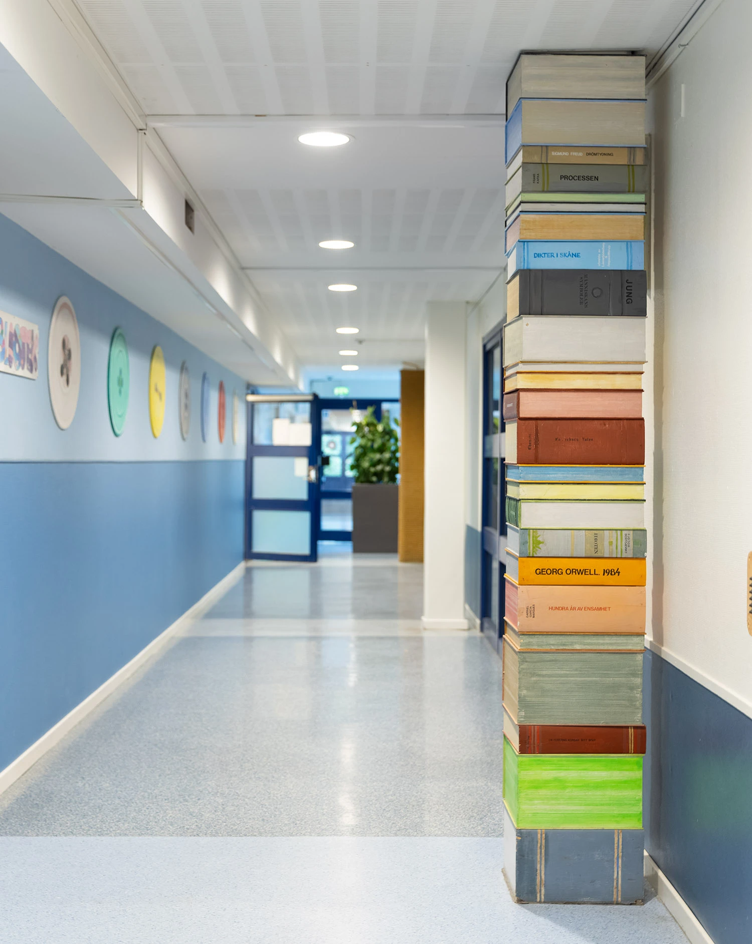 Interiör med boktrave i trä som når upp till taket.