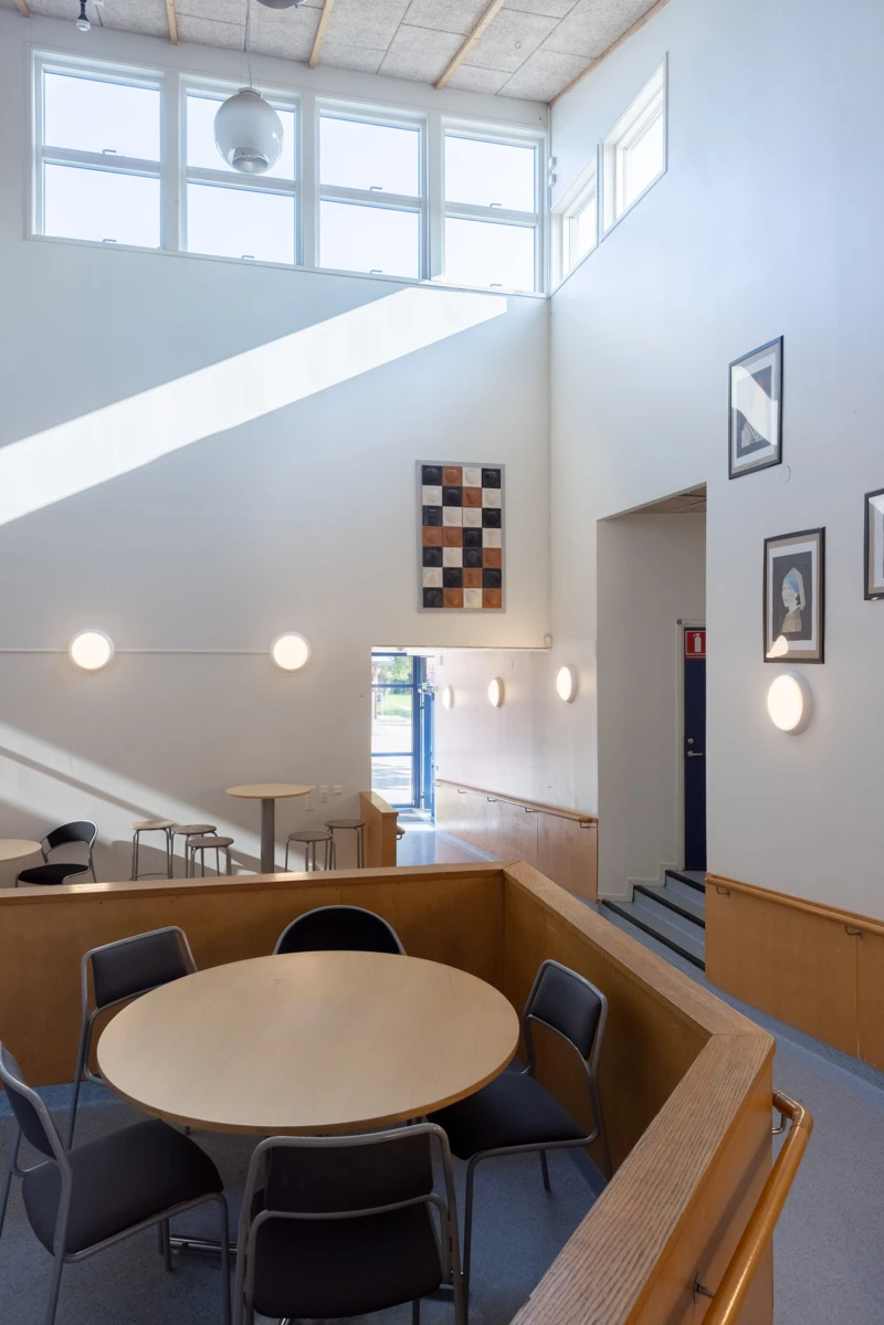 Interiör med relief i keramik med plattor med äppelformer på. Keramiken är i svart, vitt och rödbrun. 