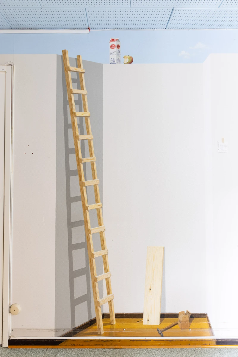Målning på vägg med en stege som står lutad mot en imaginär vägg.