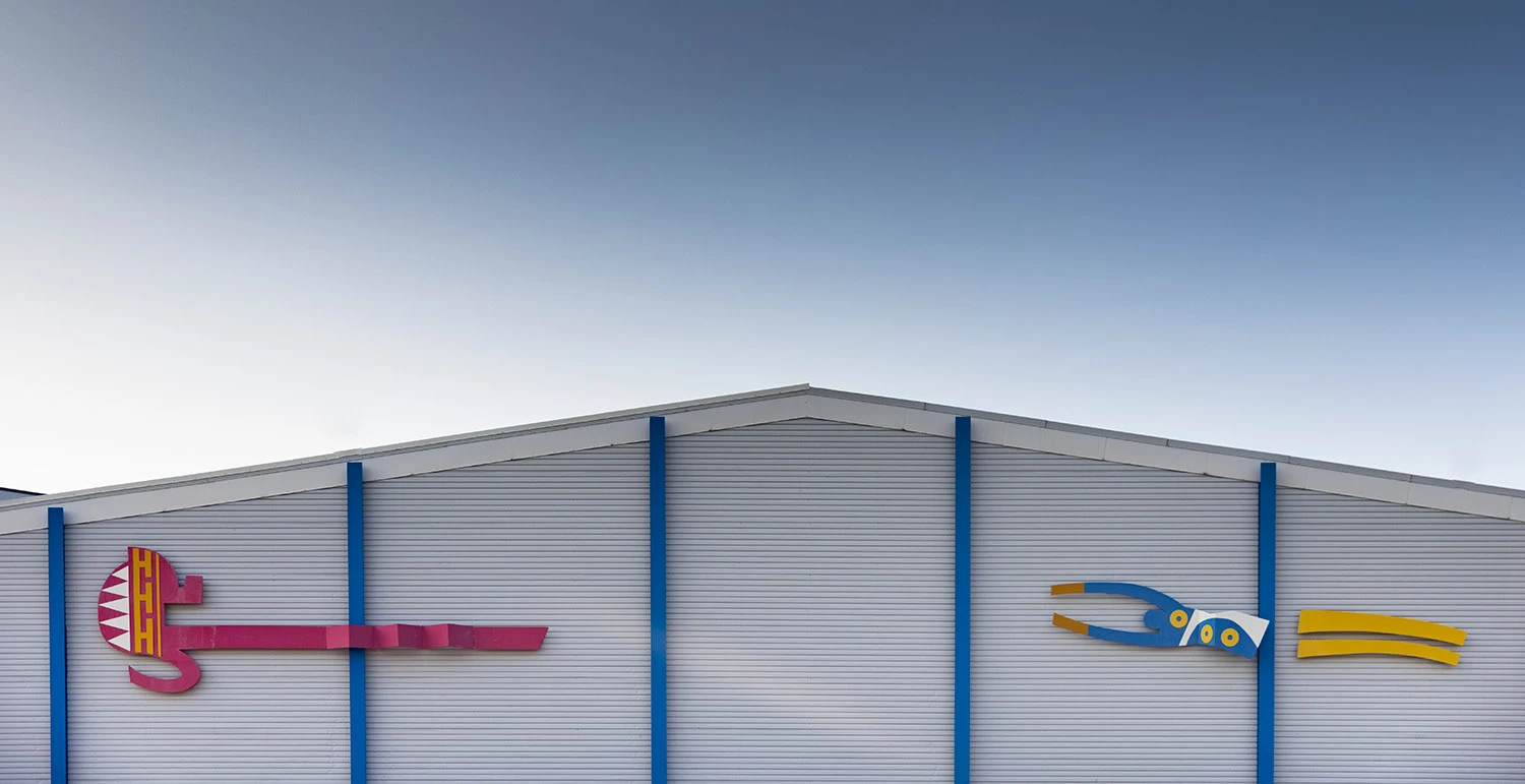 Plåtfasad med två stiliserade fotbollspelare.