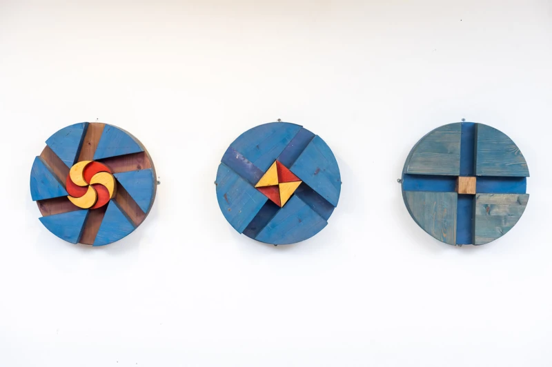 Interiör med tre runda former i blått med gul/rött centrum. Skapade i trä. 