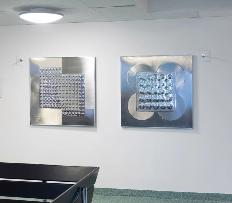 Interiör med två tavlor i blänkande stål.