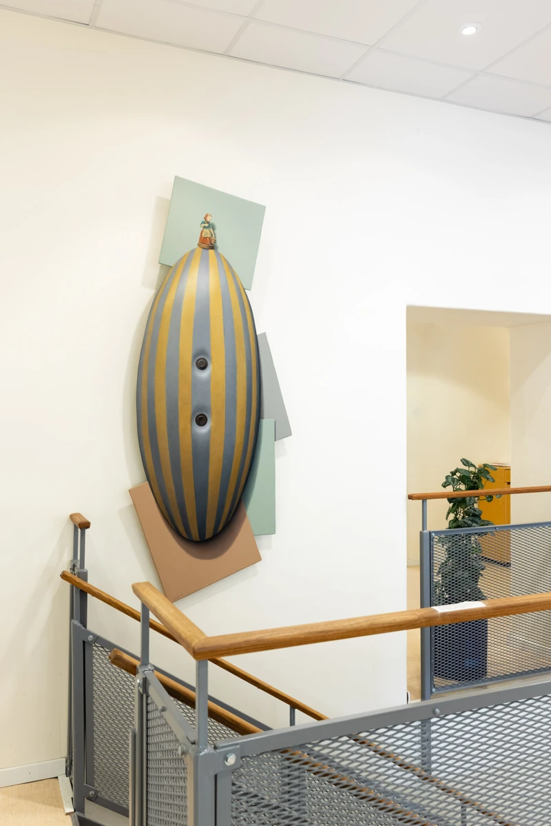 Formskuren målning som ser ut som en randig karamell som sitter bultad fast i väggen. 