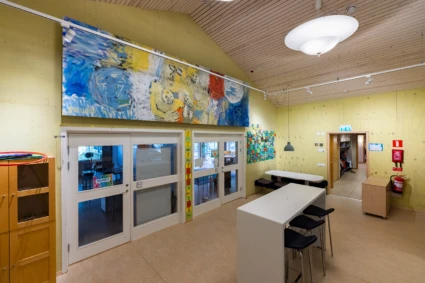 Interiör med stor, delvis abstrakt, målning blå, vit, röd och gul.