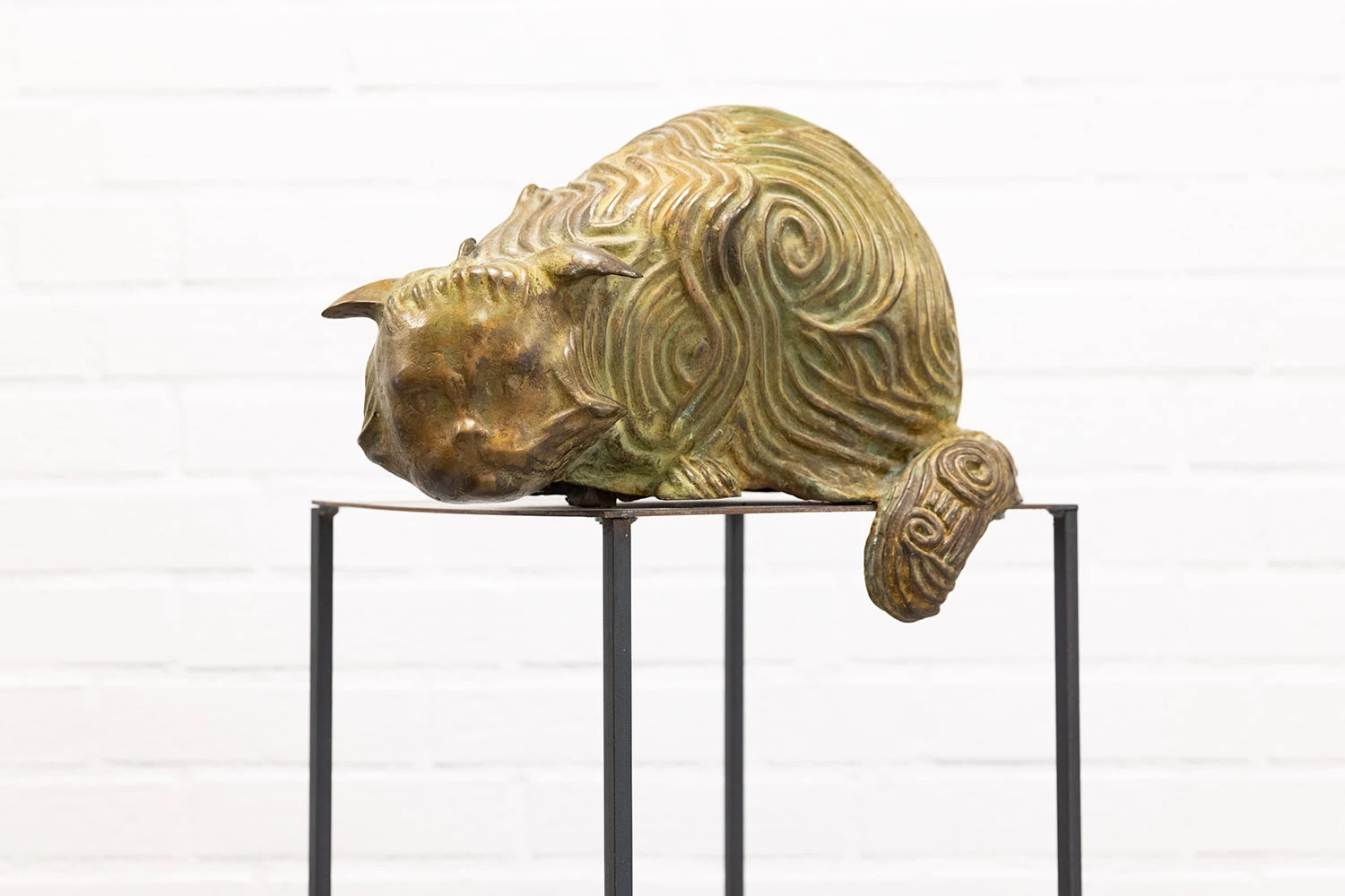 Skulptur av katt med spiralformade mönster i pälsen.