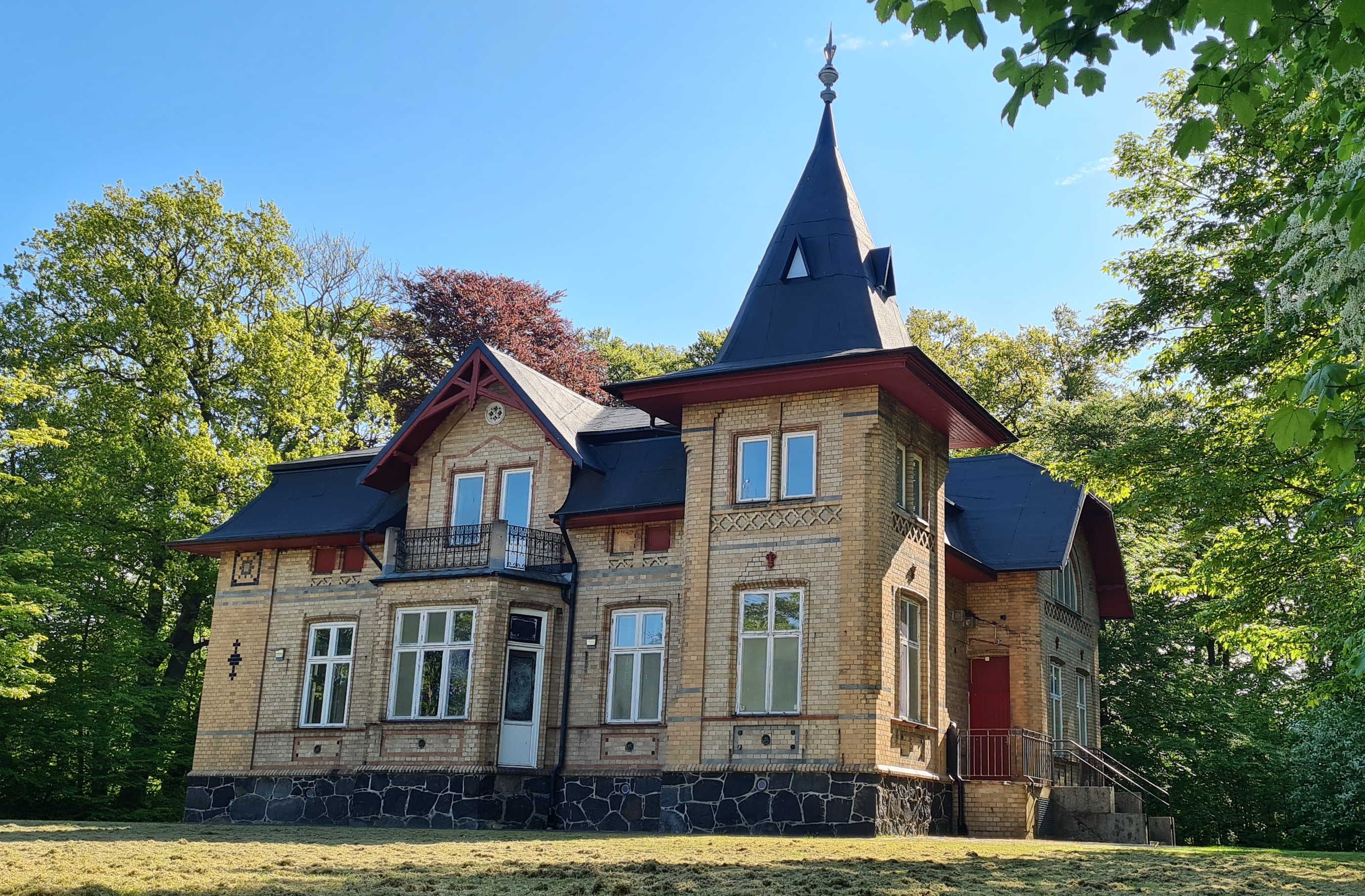 Tegelhus med torn i sommarmiljö.