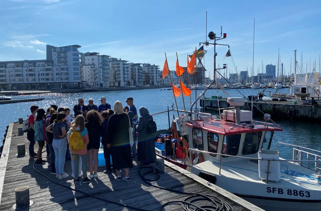 Båtar och barn i en hamn.