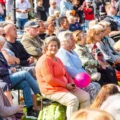 Alla i publiken tittar på scenen utom en kvinna som tittar åt ett annat håll.