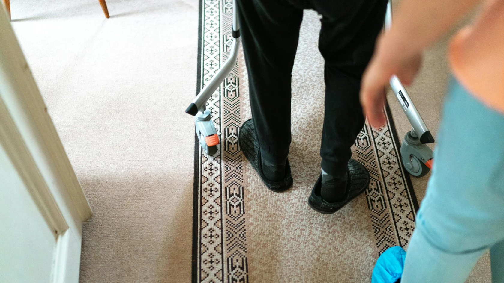 En äldre människa tar sig fram med hjälp av en rullator.