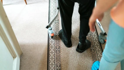 En äldre människa tar sig fram med hjälp av en rullator.