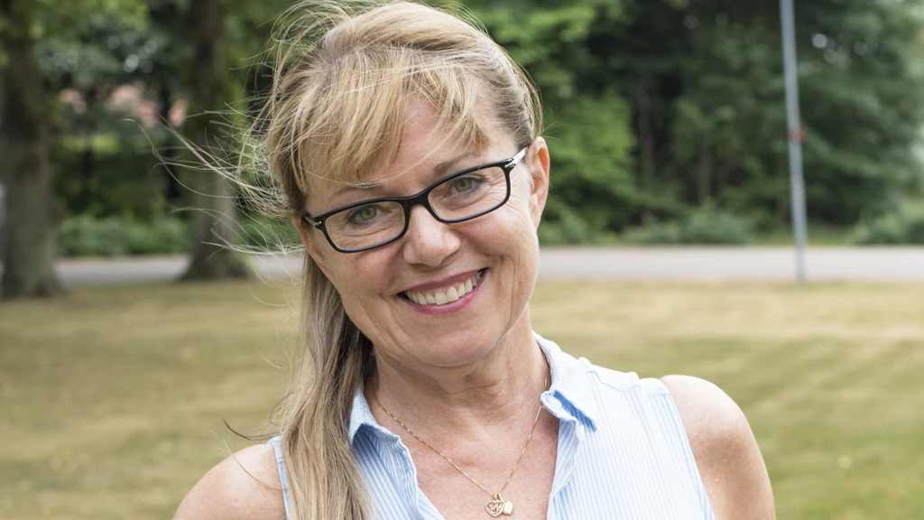Kvinna med ljust uppsatt hår och glasögon