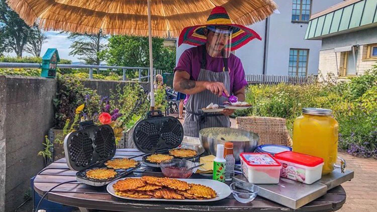 I trädgården på Dunkerska huset serverar undersköterskan Reyky Diangson våfflor. Bild från Dunkerska husets Instagram.