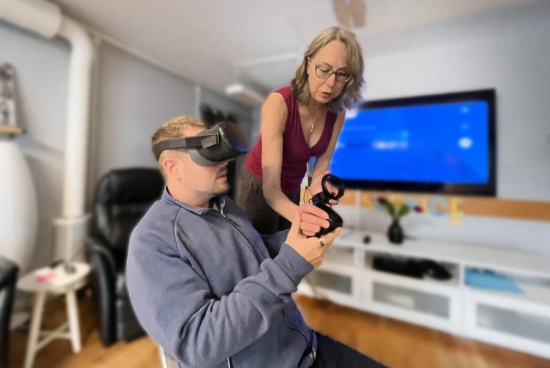 Annika instruerar deltagaren Micke på den dagliga verksamheten Zenit som är på väg att uppleva en tur i berg- och dalbanan i VR.