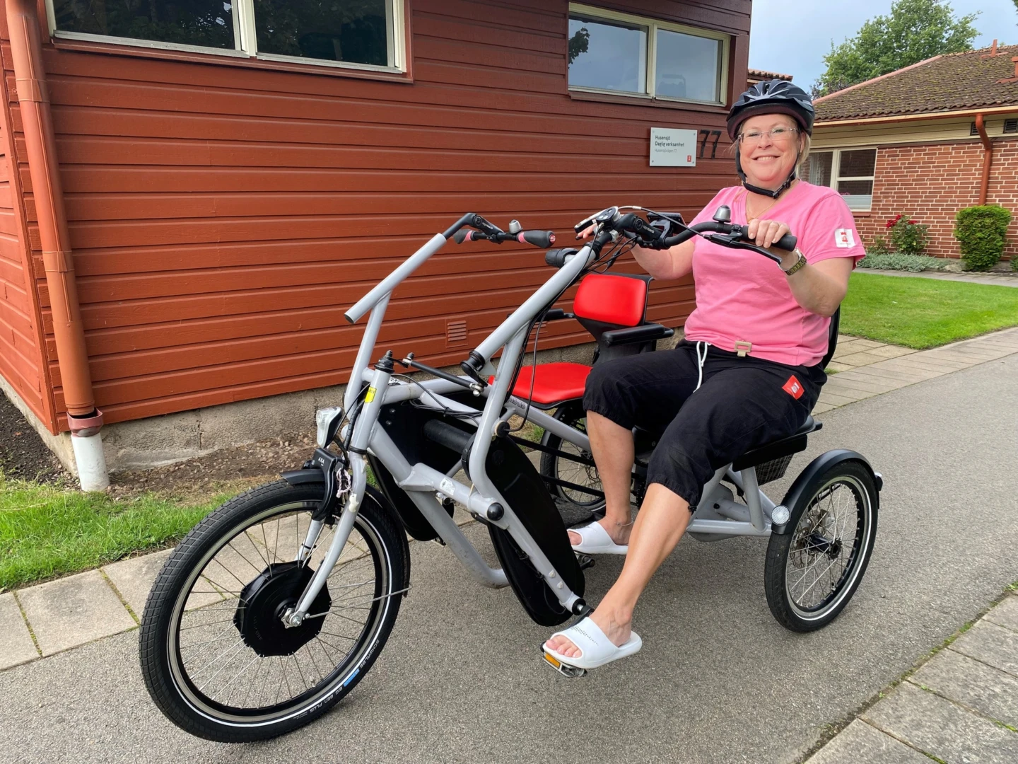 Person på cykel, ler in i kamera.