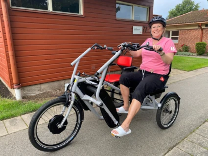 Person på cykel, ler in i kamera.