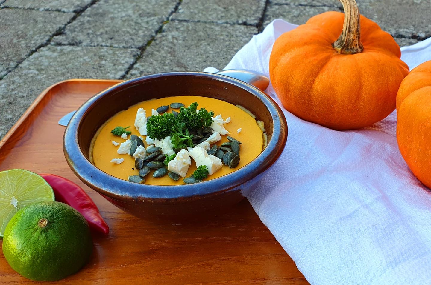 En tallrik pumpasoppa stående på enn träbricka