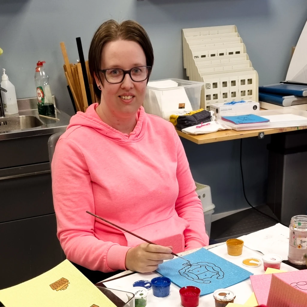 En kvinna ler och tittar in i kameran.