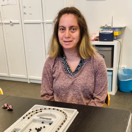 En kvinna ler och tittar in i kameran.